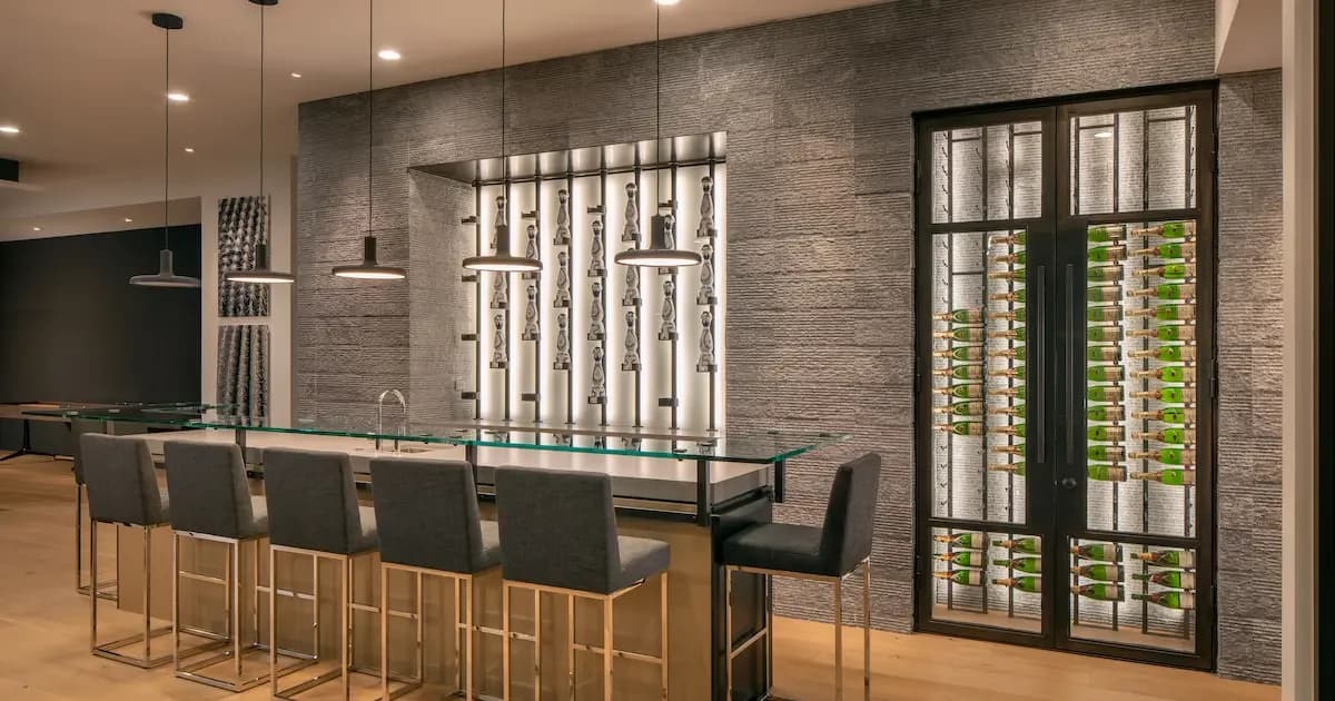 Glass-front wine displays flank a contemporary bar with tall stools.
