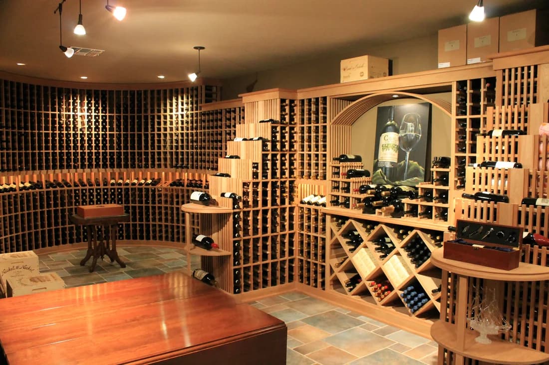 Wood racks, display niches, and a tasting counter in a traditional wine cellar.