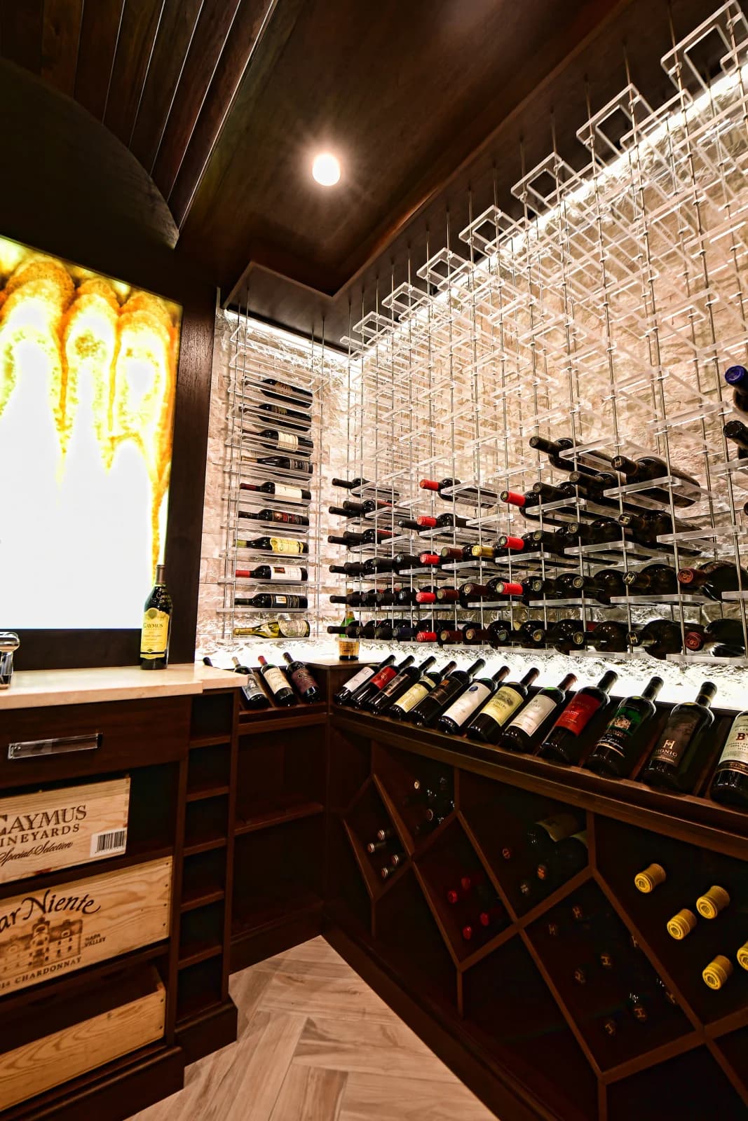 Metal bottle displays and dark wood storage beneath a wood cellar ceiling.