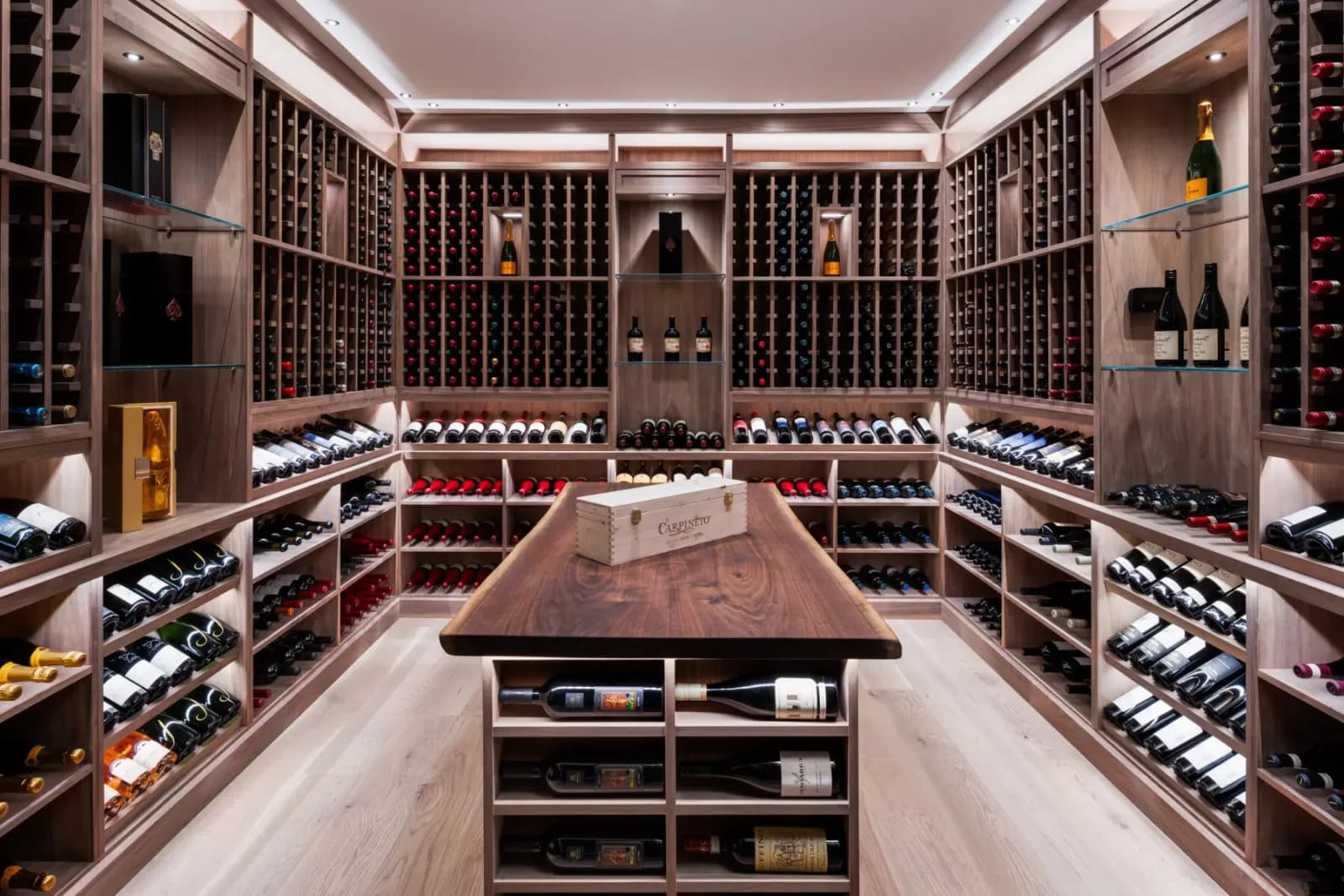 A traditional wine cellar with wood racking, case storage, and a central tasting island.