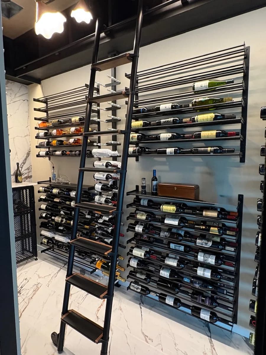 A wood wine cellar with floor-to-ceiling racking and a rolling ladder.